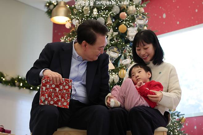 윤석열 대통령이 22일 서울 용산 대통령실에서 열린 ‘히어로즈 패밀리와 함께하는 꿈과 희망의 크리스마스’ 행사에서 한 어린이에게 선물을 전달하고 있다. 윤 대통령은 이날 전몰·순직한 군인, 경찰, 소방관 등의 배우자와 초등학생 이하 자녀 등 30여 명을 대통령실로 초청했다./대통령실