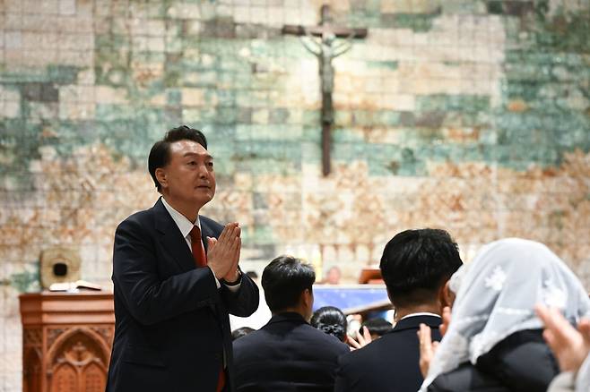 윤석열 대통령이 24일 오후 서울 종로구 혜화동 성당에서 열린 '주님 성탄 대축일 미사'에 참석해 주임신부의 소개에 따라 자리에서 일어나 신도들에게 인사하고 있다./대통령실