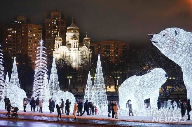 [모스크바=AP/뉴시스] 러시아 유명 조각가 베라 무히나의 새해와 크리스마스 축하 스테인리스 작품이 설치된 모스크바의 한 공원에서 24일(현지시각) 시민들이 즐거운 시간을 보내고 있다. 2023.12.25.