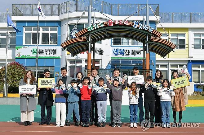 제주지사·교육감, 제주어 교육 시범학교 방문 (제주=연합뉴스) 오영훈 제주지사와 김광수 제주교육감 등 제주도와 제주도교육청 관계자들이 26일 '제주어 교육 시범학교'인 창천초등학교를 찾아 제주어 수업에 참여한 뒤 학생들과 기념 촬영을 하고 있다. 2023.12.26 [제주도교육청 제공. 재판매 및 DB 금지] atoz@yna.co.kr