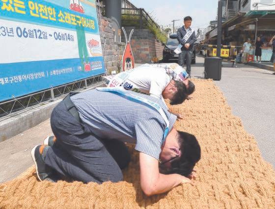 지난 6월 14일 인천시 남동구 소래포구 전통어시장에서 상인들이 자정대회를 열고 신뢰 회복을 약속하며 사과하고 있다. 연합뉴스