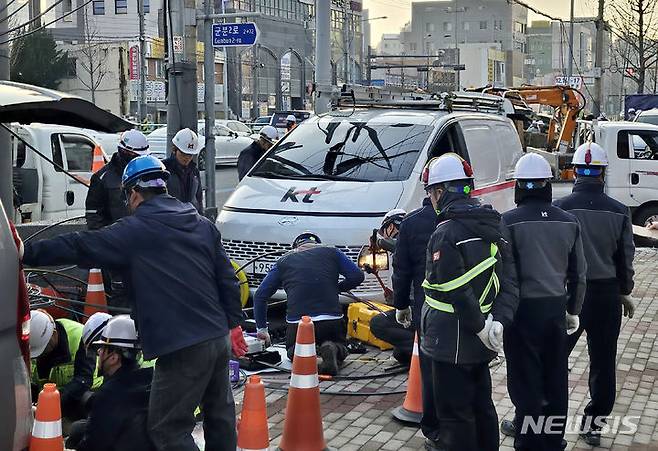 [광주=뉴시스] 이영주 기자 = KT 직원들이 27일 오후 광주 서구 화정동 하수관공사현장 주변에서 손상된 인터넷 광케이블 복구 작업에 나서고 있다. (사진 = 독자 제공) 2023.12.27. photo@newsis.com