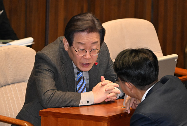 이재명 더불어민주당 대표가 28일 국회 본회의장에서 같은 당 조정식 의원과 대화를 하고 있다. 이날 ‘대장동 50억 클럽 특검법’이 28일 국회 본회의장에서 통과되면서 이 대표 관련 검찰 수사가 특검으로 이관될 수 있다는 관측이 나온다.  최현규 기자