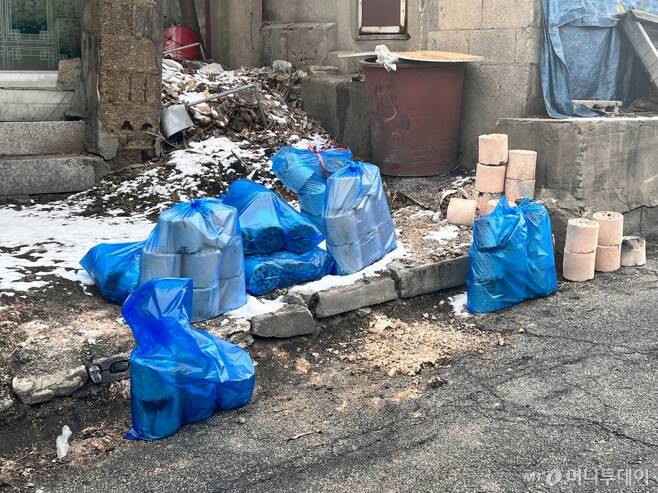지난 26일 서울 노원구 백사마을 골목길에 주민들이 사용한 연탄이 파란색 봉투에 싸여 놓여있다./사진=민수정 기자