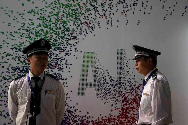 AI 표식 앞에 서 있는 중국 공안/로이터 연합뉴스