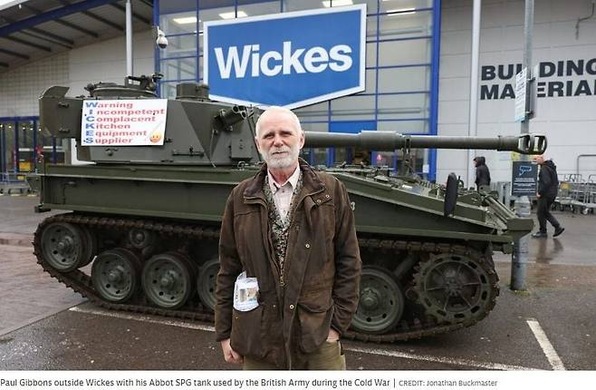 폴 기번스가 주방 인테리어 업체 '윅스' 매장에 탱크를 끌고 가 부실 공사에 대한 항의를 하고 있다. /텔레그래프 보도화면 캡처