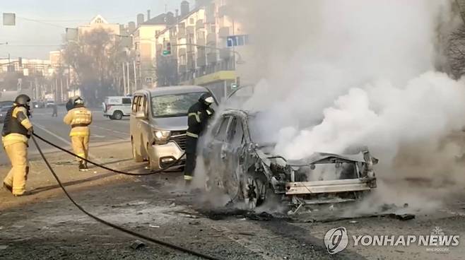 30일(현지시간) 러시아 서부 벨고로드에서 우크라이나군의 포격을 맞은 차량에 화재가 발생, 소방대원들이 이를 진화하고 있다. [로이터=연합뉴스]