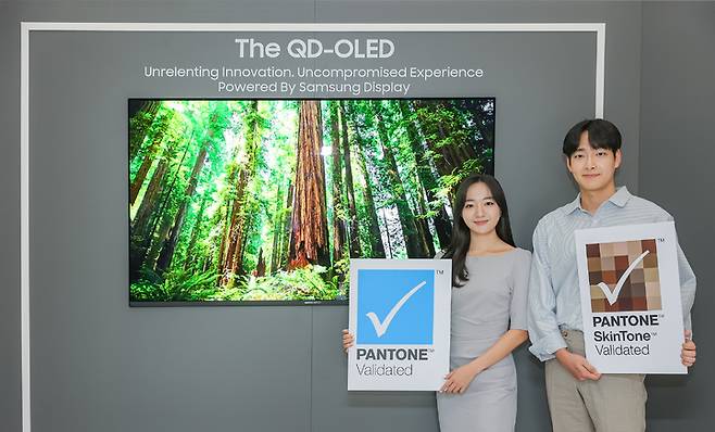 [서울=뉴시스] 삼성디스플레이 직원들이 TV용 QD-OLED 앞에서 '팬톤 컬러 인증' 및 '팬톤 스킨톤 인증' 로고를 들고 기념 촬영을 하고 있다. (사진=삼성디스플레이) 2023.06.06. photo@newsis.com  *재판매 및 DB 금지