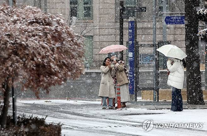 새해 앞두고 대설주의보 (서울=연합뉴스) 윤동진 기자 = 대설주의보가 내려진 30일 오전 서울 중구 덕수궁 인근에서 관광객들이 사진을 찍고 있다. 2023.12.30 mon@yna.co.kr