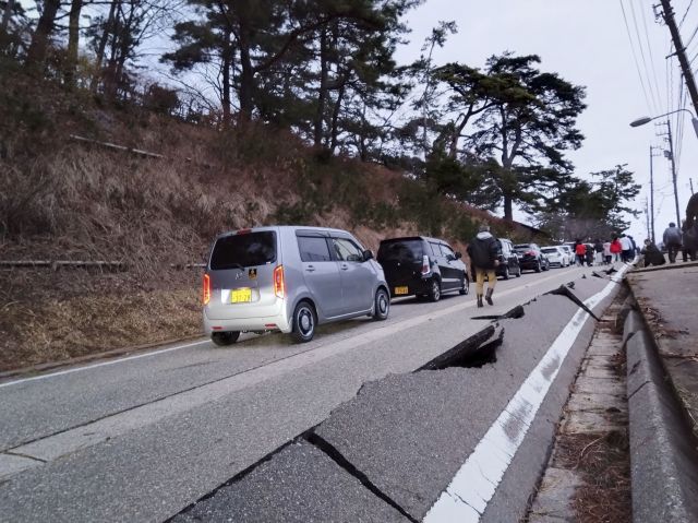 일본 이시카와현 와지마 인근을 차량으로 지나던 운전자들이 1일 발생한 지진으로 갈라진 도로로 나와 있다. 로이터연합뉴스