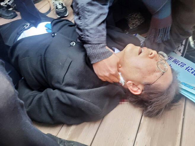 이재명 더불어민주당 대표가 2일 부산 가덕도 신공항부지 방문 중 피습을 당해 바닥에 쓰러져 있다.(사진=연합뉴스)
