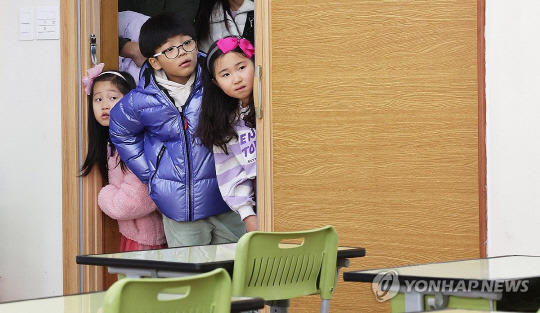 지난달 26일 오후 경기도 수원시 영통구 영덕초등학교에서 열린 신입생 예비 소집에서 예비 초등학생들이 부모님과 교실을 살펴보고 있다. 연합뉴스