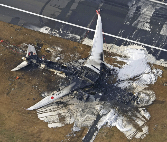 잿더미가 된 항공기 3일 일본 도쿄 하네다 공항 활주로에 전날 착륙 중 해상보안청 항공기와 충돌해 전소된 일본항공(JAL) 여객기 잔해가 흩어져 있다.  AP 연합뉴스