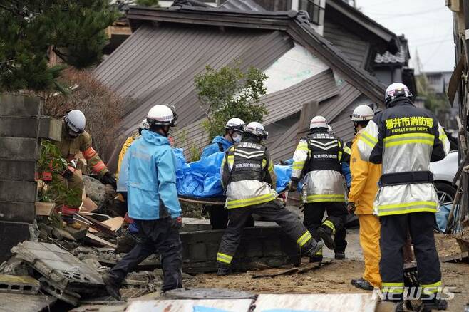 [스즈=AP/뉴시스] 3일 일본 이시카와현 스즈의 소방관과 구조대원들이 지진으로 무너진 집에서 수습한 시신을 옮기고 있다. 지난 1일 이시카와현 노토반도에서 발생한 지진으로 지금까지 사망자 숫자는 최소 62명으로 늘어났다. 2024.01.03.
