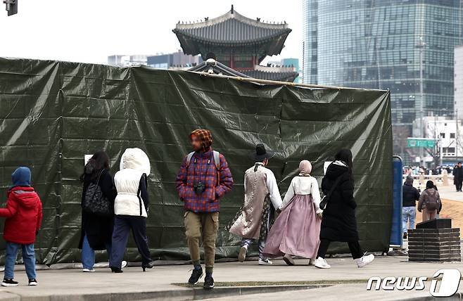 29일 서울 종로구 경복궁 영추문 인근 낙서로 훼손된 담장이 안내문과 함께 가림막에 가려져 있다. 문화재청은 이날까지 세척과 색맞춤 등 후반 작업과 전문가 자문 등을 마친 뒤 내년 1월 4일 낙서 제거 작업을 마친 담장을 공개할 예정이다. 2023.12.29/뉴스1 ⓒ News1 구윤성 기자