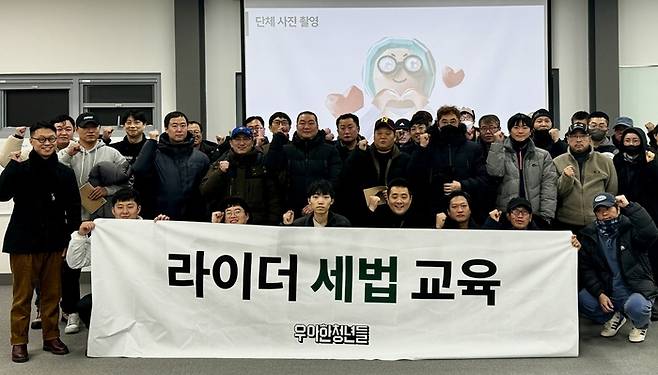 우아한청년들은 경기 남양주시 배민라이더스쿨에서 배민 커넥트 라이더 대상 라이더 세법교육을 진행했다. 참석자들이 기념사진을 촬영하고 있다. 〈자료 우아한청년들〉