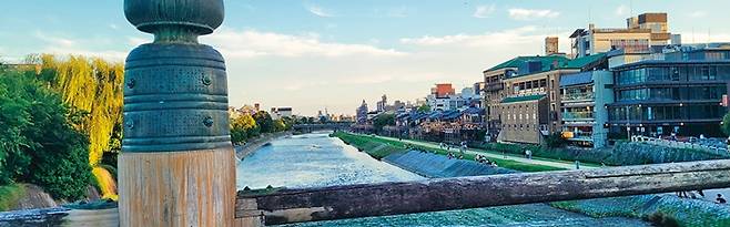 산조대교에서 바라본 하류 쪽 가모가와 강. 오른쪽에 등을 달고 늘어선 노천식당들이 교토의 여름 명물 ‘노료유카’이다. 오른쪽 녹색 지붕 건물은 폰토초 가부키극장.