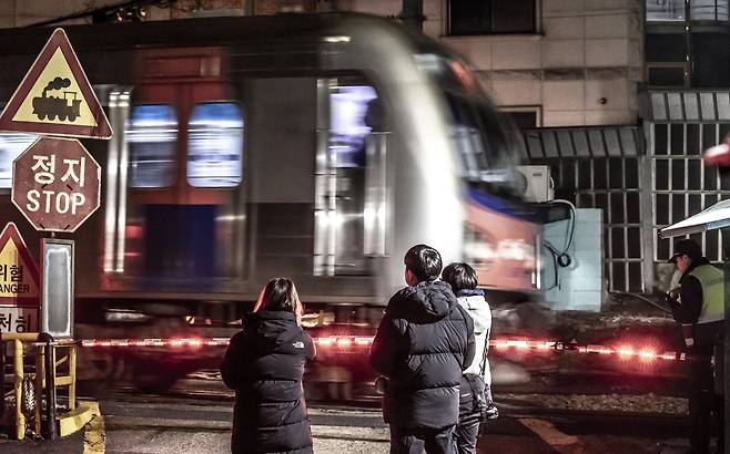 1호선 회기역 앞 주택가에 있는 휘경2건널목을 열차가 통과하고 있다. 보행 차단봉과 함께 '땡땡땡' 추억의 소리가 울리는, 서울에 몇 남지 않은 풍경이다. /이신영 영상미디어 기자
