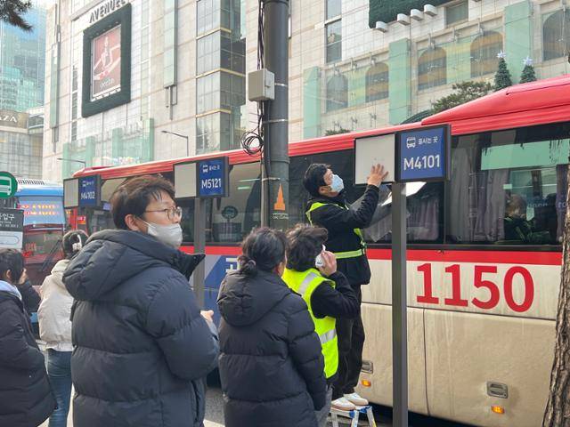 서울 명동입구 광역버스 정류장에 설치된 노선별 대기판이 오히려 혼잡을 야기한다는 지적이 나오자 5일 회수되고 있다. 권정현 기자