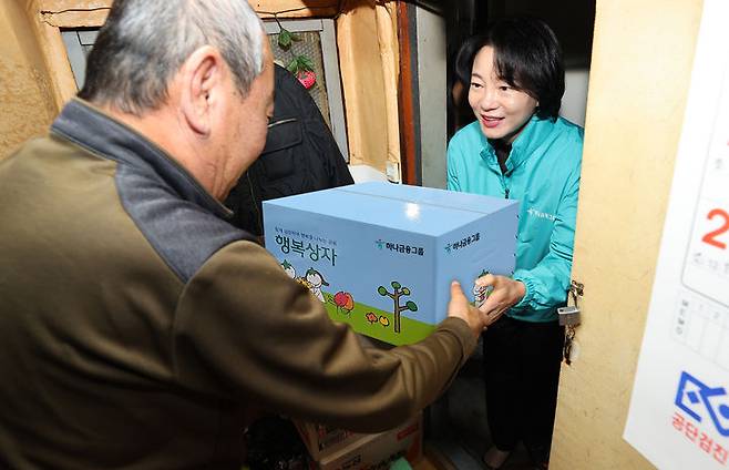 6일 김덕순 하나은행 북부영업본부 지역대표(오른쪽)가 서울 창신동 인근 쪽방촌을 방문해 독거노인에게 행복상자를 건네고 있다. (사진=하나금융 제공) *재판매 및 DB 금지