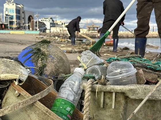 8일 오전 8시 제주시 이호해수욕장을 뒤덮은 해양쓰레기를 바다환경지킴이들이 수거하고 있다. 밀려온 쓰레기 중 생수 페트병 라벨에는 중국어 간체자가 쓰여있다. 최충일 기자