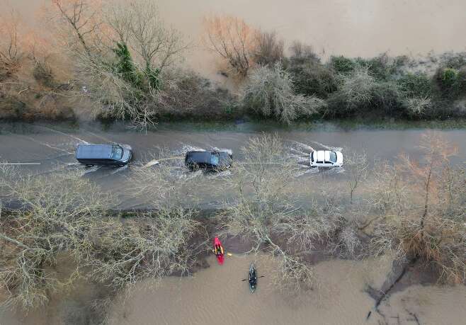 2024년 1월 6일(현지시각) 영국 풀버러에서 폭풍 헨크의 여파로 아룬 강이 범람한 가운데 자동차들이 침수된 도로를 따라 조심스럽게 운행하고 있다. / 로이터 연합뉴스