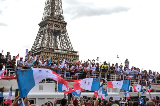 지난해 7월 25일(현지시간) 2024 파리 올림픽을 앞두고 파리 센강에서 랜드마크 에펠탑을 배경으로 사람들이 올림픽 성화 행사를 하고 있다. AFP=연합뉴스