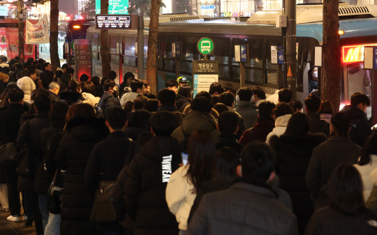 서울을 비롯한 수도권 대부분 지역에 눈이 내린 9일 오후 서울 중구 명동입구 정류장에서 시민들이 버스를 타기 위해 기다리고 있다. 연합뉴스