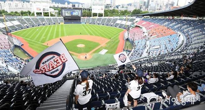 신종 코로나바이러스 감염증(코로나19) 사태로 닫혔던 프로스포츠 관중석이 열렸다. 프로야구 관중 입장 첫 날인 26일 서울 잠실야구장을 찾은 시민들이 거리를 두고 응원하고 있다. 문체부는 이날 진행되는 프로야구 경기부터 관중석 10%의 규모로 관중을 입장시키기로 했다./김현민 기자 kimhyun81@