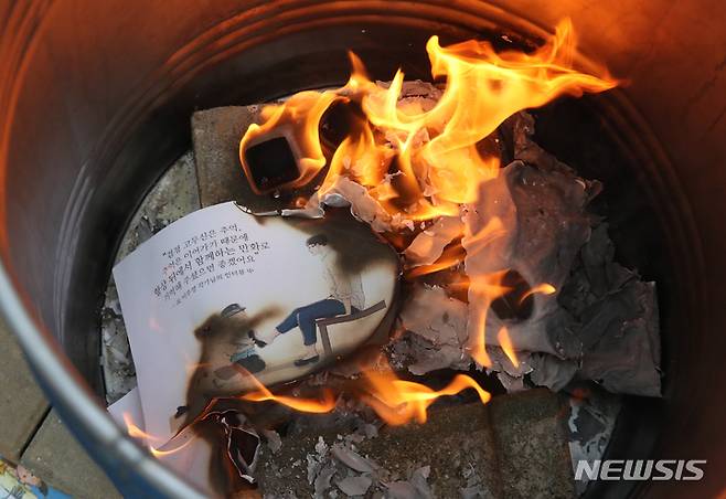 [파주=뉴시스] 고승민 기자 =이우영작가사건대책위원회, 한국만화가협회, 한국웹툰작가협회 회원들이 15일 경기 파주 형설출판사 앞에서 불공정계약 규탄 및 '검정고무신' 장례집회 기자회견을 연 가운데 참가자들이 팬아트를 태우는 영결식 퍼포먼스를 하고 있다. 2023.05.15. kkssmm99@newsis.com