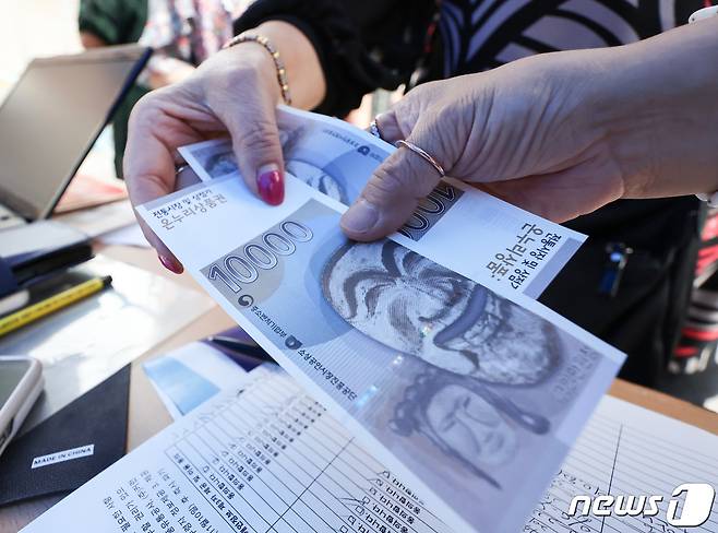 서울 종로구 광장시장에서 시민들이 온누리상품권을 받고 있다. /뉴스1 ⓒ News1 김민지 기자