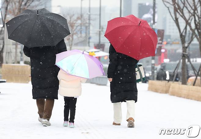 서울 종로구 광화문광장 일대에서 한 가족이 우산을 쓰고 발걸음을 옮기고 있다. 2024.1.9/뉴스1 ⓒ News1 김민지 기자