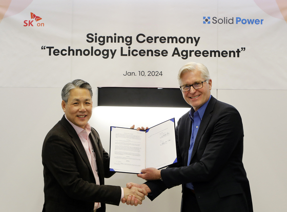 SK On Chief Commercial Officer Sung Min-suk, left, and Solid Power CEO John Van Scoter pose for a photo after signing a technology agreement on Jan. 10 at CES 2024 in Las Vegas. [SK ON]