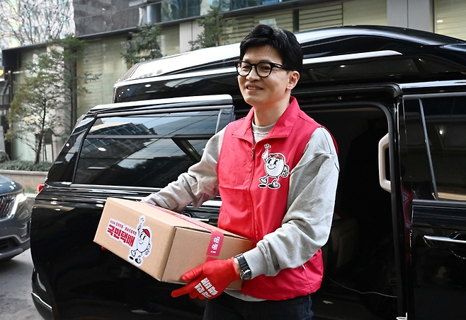 18일 오후 저출생 관련 공약인 ‘일·가족 모두행복’이 담긴 국민택배를 든 한동훈 국민의힘 비상대책위원장이 서울 강남구 휴레이포지티브로 들어가고 있다.  [한주형 기자]