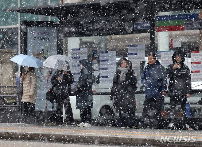 [서울=뉴시스] 김명년 기자 = 눈이 내린 17일 오전 서울 서초구 강남대로에서 시민들이 버스를 기다리고 있다. 2024.01.17. kmn@newsis.com