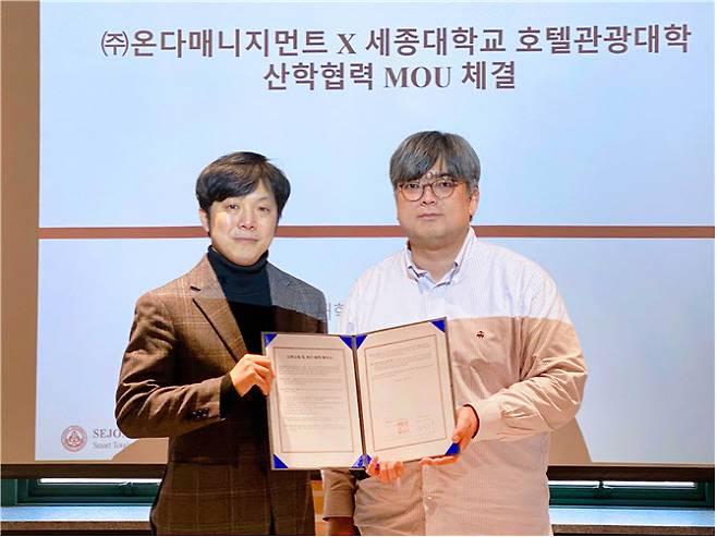 11월2일 고영대 세종대 호텔관광경영학전공 교수(오른쪽)와 정진태 ㈜온다매니지먼트 대표가 협약서를 들고 기념촬영을 하고 있다. (사진 제공=세종대)