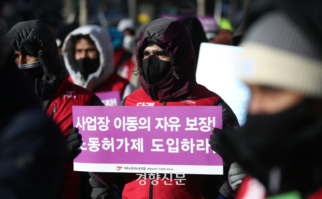 한 이주노동자가 2022년 1218일 서울 중구 파이낸스센터 앞에서 열린 세계 이주노동자의 날 기념대회에서 사업장 이동의 자유 보장과 노동허가제 도입을 촉구하는 손팻말을 들고 있다. 권도현 기자