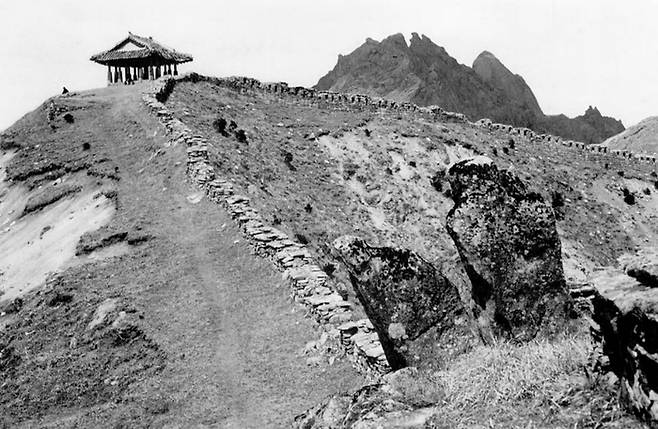 북한산 동장대(1900년대 초). 북한산 대동문에서 동장대로 가는 산성길이다. 뒷쪽으로 인수봉, 만경봉이 보인다. 지금은 숲이 우거져있지만 당시만 해도 나무는 커녕 풀도 드물다. [서울역사박물관(성 베네딕도 상트 오틸리엔 수도원 소장 서울사진)]