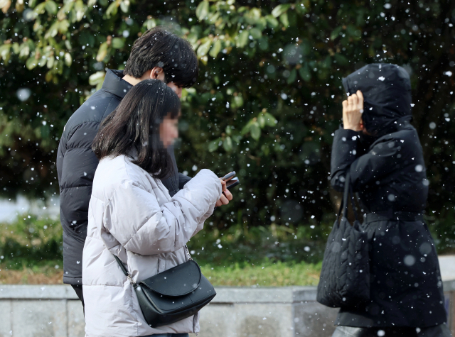 22일 광주 서구 유스퀘어 앞에서 시민들이 날리는 눈발 속을 걷고 있다. 연합뉴스