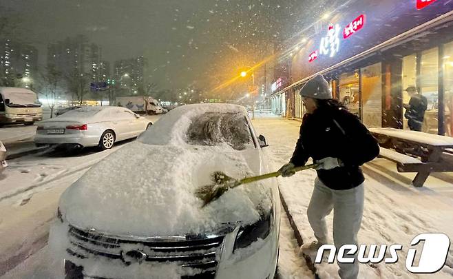 광주와 전남 11개 시군에 대설주의보가 내려진 22일 광주시 광산구 수완지구 상가에서 주민이 차량에 쌓인 눈을 치우고 있다. 2024.1.22/뉴스1 ⓒ News1 김태성 기자