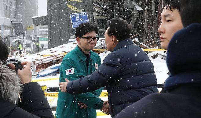 윤석열 대통령이 23일 충남 서천군 서천읍 서천특화시장 화재 현장에서 국민의힘 한동훈 비상대책위원장과 만나 인사하고 있다. 연합뉴스