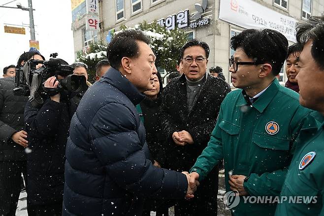 악수하며 헤어지는 윤석열 대통령과 한동훈 비대위원장 (서울=연합뉴스) 진성철 기자 = 윤석열 대통령이 23일 충남 서천군 서천읍 서천특화시장 화재 현장에서 국민의힘 한동훈 비상대책위원장과 함께 현장을 점검한 뒤 떠나며 악수하고 있다. 2024.1.23   [대통령실 제공. 재판매 및 DB 금지] zjin@yna.co.kr