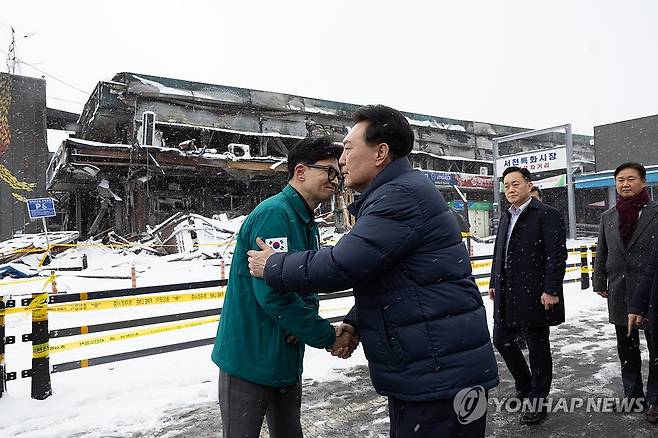 악수하는 윤석열 대통령과 한동훈 비대위원장 (서울=연합뉴스) 진성철 기자 = 윤석열 대통령이 23일 충남 서천군 서천읍 서천특화시장 화재 현장에서 국민의힘 한동훈 비상대책위원장과 만나 악수하고 있다. 2024.1.23   [대통령실 제공. 재판매 및 DB 금지] zjin@yna.co.kr