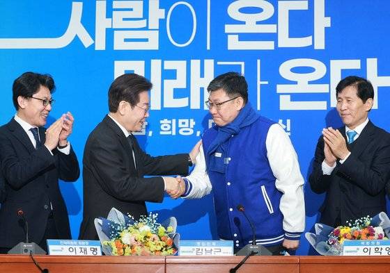 더불어민주당 이재명 대표가 24일 오전 국회에서 열린 인재환영식에서 김남근 변호사에게 당 점퍼를 입혀준 뒤 기념촬영을 하고 있다. 연합뉴스