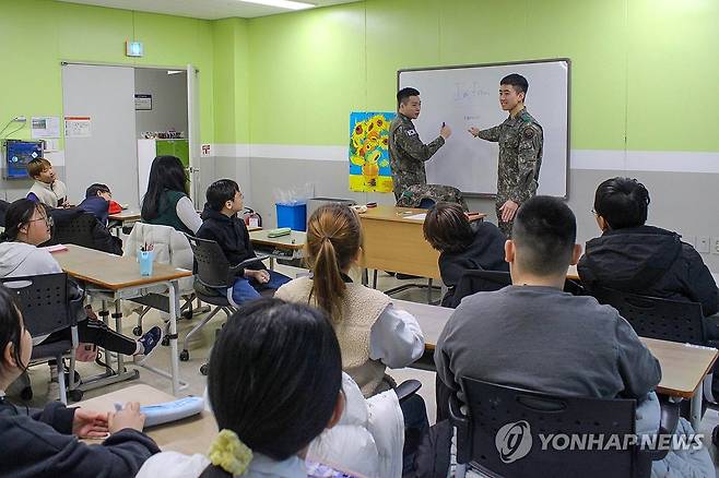 '군인 선생님'으로 변신한 육군 흑곰대대 병사들 (강원 고성=연합뉴스) 육군 제3포병여단은 흑곰대대 이광로(22)·임성민(21)·이윤석(22) 병장이 올해 1월부터 지역 초등학생들을 대상으로 교육 봉사활동을 하고 있다고 24일 밝혔다. 사진은 임성민(오른쪽)·이윤석 병장이 강원 고성청소년수련관에서 학생들에게 영어를 알려주는 모습. 2024.1.24 [육군 제3포병여단 제공. 재판매 및 DB 금지] conanys@yna.co.kr