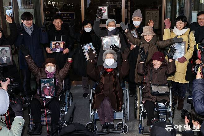 25일 오전 서울 서초구 대법원에서 열린 일제 강제동원 후지코시 상대 손배소송 상고심 선고에서 원고 일부승소 판결 원심을 확정받은 피해자 김정주(앞줄 왼쪽부터), 김계순, 이자순 할머니와 유족들이 만세를 하고 있다. 이한결 기자 always@donga.com