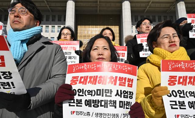 김미숙(가운데) 김용균재단 대표 등 민주노총과 생명안전행동, 정의당 등 관계자들이 24일 서울 영등포구 여의도 국회 본청 앞에서 50인 미만 사업장에 대한 중대재해처벌법 적용 유예 연장을 반대하는 기자회견을 열고 있다. 정부와 여당은 현장의 준비 미비를 이유로 '2년 추가 유예'를 추진해왔으나, 여야 합의 실패로 25일 국회 본회의 처리는 무산됐다. 정다빈 기자