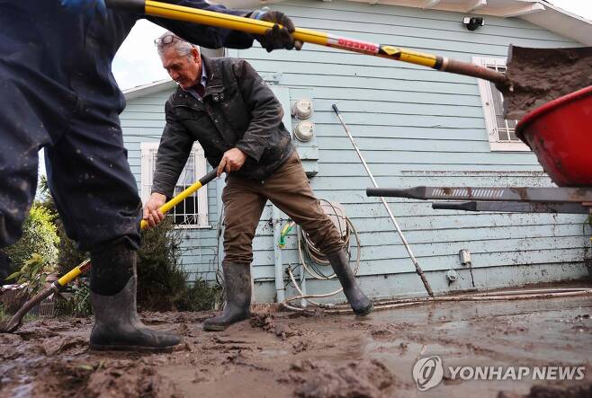 주택가에 떠내려온 진흙을 치우는 샌디에이고 주민들 [AFP=연합뉴스. 재판매 및 DB 금지]