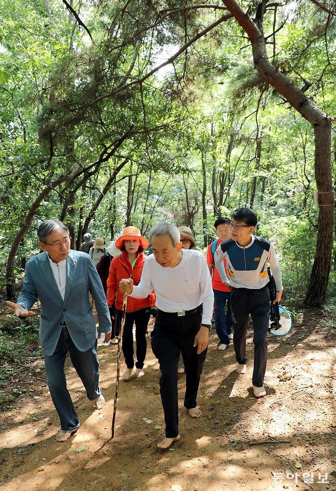 박성태 씨(앞 오른쪽)가 박동창 맨발걷기국민운동본부 회장(앞 왼쪽)과 함께 경기 남양주 와부 금대산을 맨발로 걷고 있다. 2022년 1월 말 전립선암 말기 판정을 받은 박 씨는 그해 2월 말부터 본격적으로 맨발로 금대산을 걸어 2개월 여만에 암의 공포에서 벗어났다. 남양주=이훈구 기자 ufo@donga.com