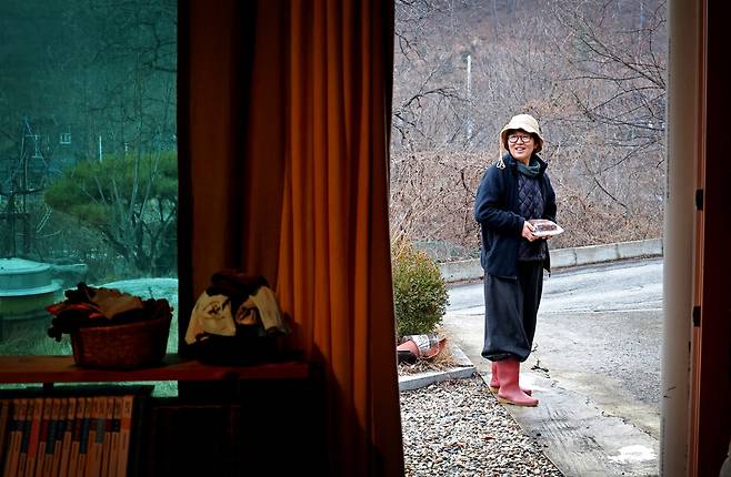김해자 시인이 11일 신년제에 올리려고 주문한 시루떡을 마을 주민들과 나누기 위해 집을 나서고 있다. 이정용 선임기자